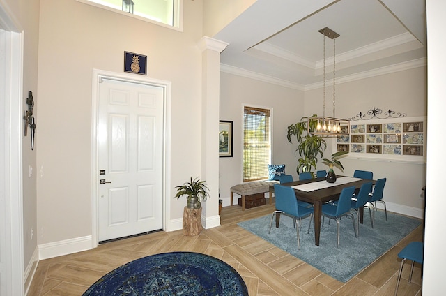 dining area featuring baseboards, a raised ceiling, ornamental molding, and a chandelier