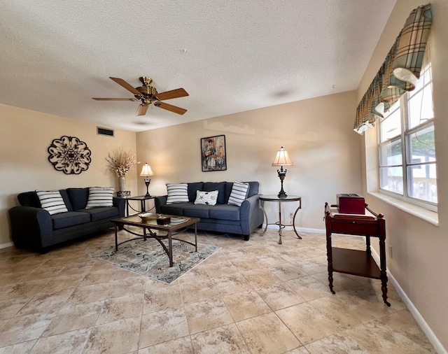 living room featuring a textured ceiling, baseboards, and ceiling fan