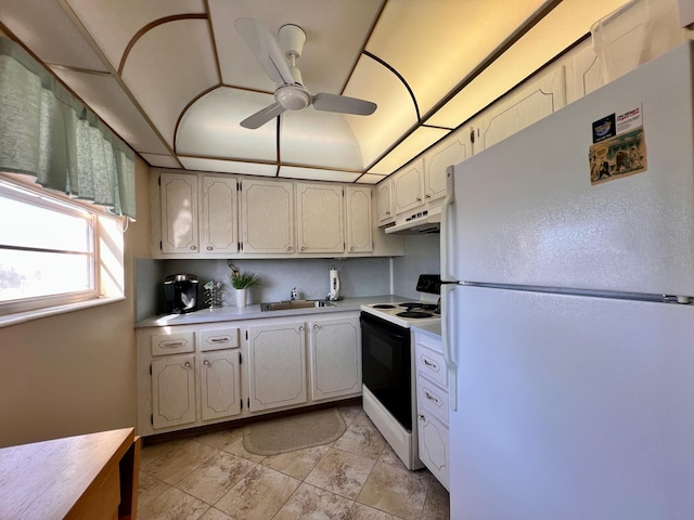 kitchen with a ceiling fan, freestanding refrigerator, a sink, range with electric cooktop, and light countertops