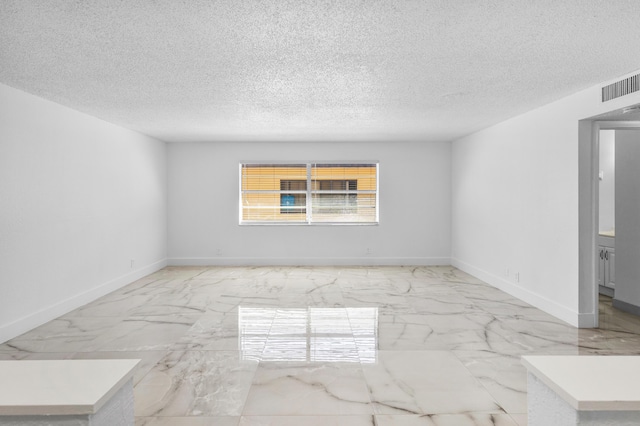 spare room with visible vents, baseboards, a textured ceiling, and marble finish floor