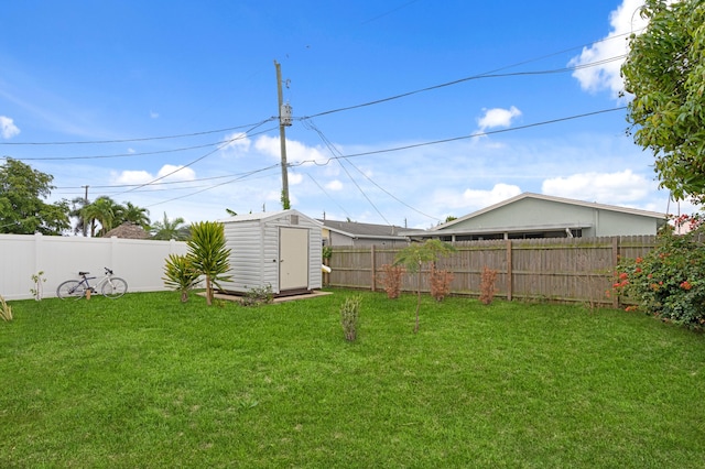 view of yard featuring an outbuilding, a fenced backyard, and a shed