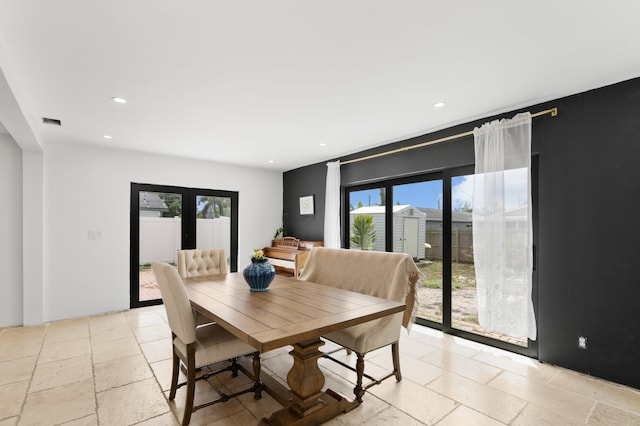 dining space with recessed lighting, stone tile flooring, and plenty of natural light