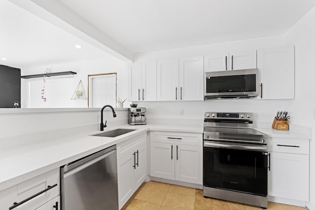 kitchen with light countertops, white cabinetry, a sink, and appliances with stainless steel finishes