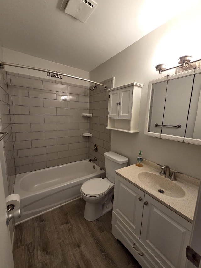 full bath featuring vanity, wood finished floors, visible vents, shower / bathing tub combination, and toilet