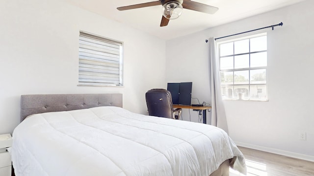 bedroom featuring wood finished floors, baseboards, and ceiling fan