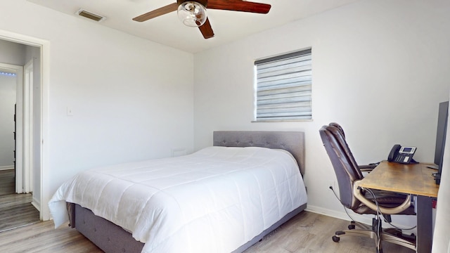 bedroom with visible vents, baseboards, ceiling fan, and wood finished floors