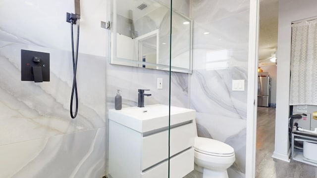 bathroom with vanity, toilet, and visible vents