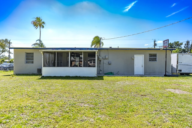 rear view of property with a yard and a sunroom