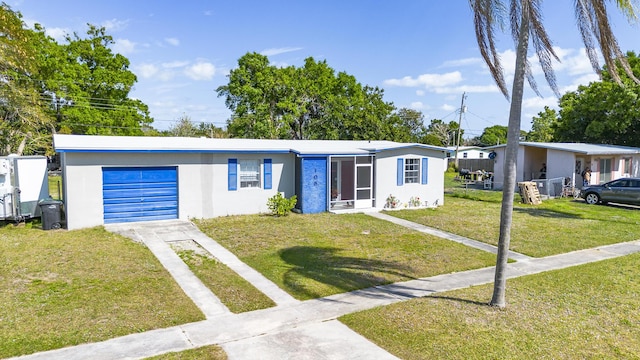 view of front of home featuring stucco siding, a front lawn, an attached garage, and driveway