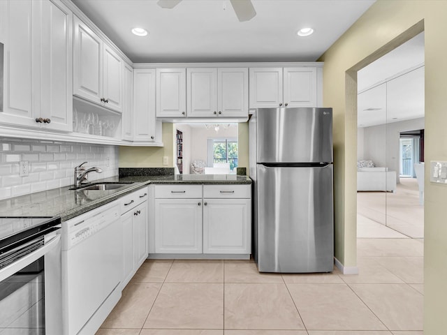 kitchen with light tile patterned flooring, white cabinets, stainless steel appliances, and dark stone counters