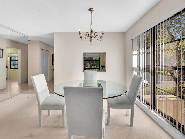 dining space featuring carpet and an inviting chandelier