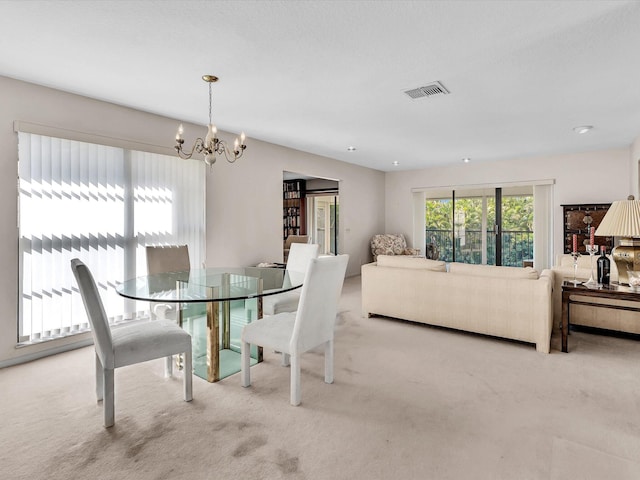 dining area with a notable chandelier, visible vents, and carpet floors