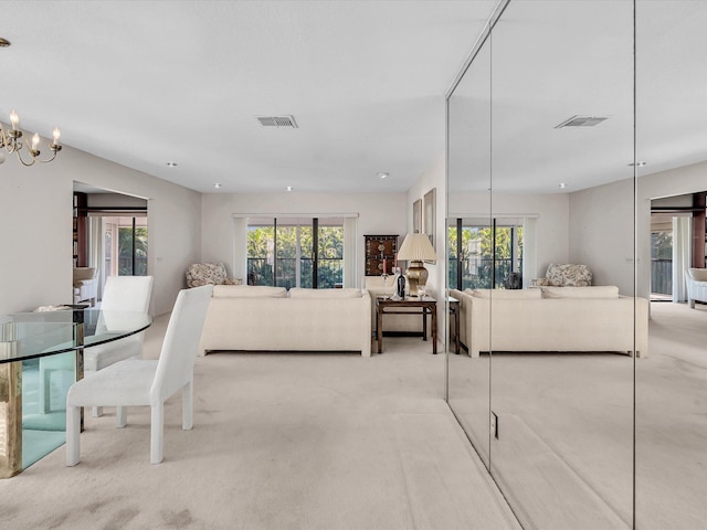 living area featuring an inviting chandelier, visible vents, and carpet floors