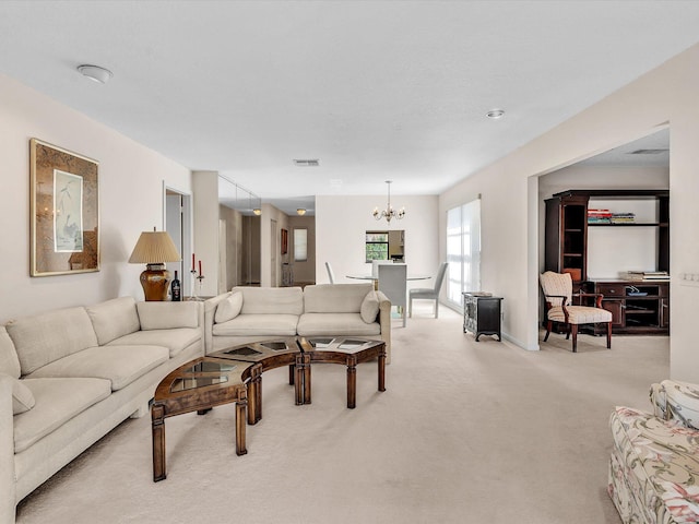 living room featuring visible vents, light carpet, and a notable chandelier