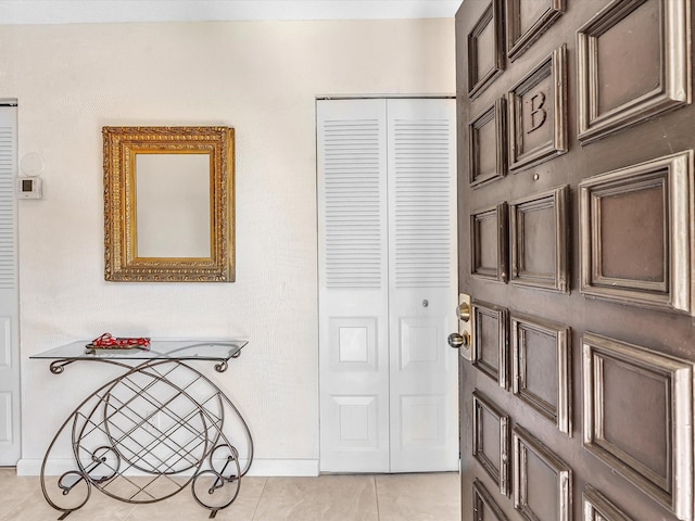 foyer entrance featuring light tile patterned floors and baseboards