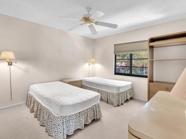 bedroom featuring a ceiling fan, a textured ceiling, and carpet flooring