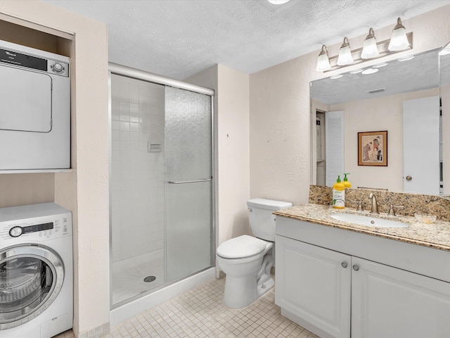 full bathroom featuring a textured ceiling, a stall shower, stacked washer and dryer, and a textured wall