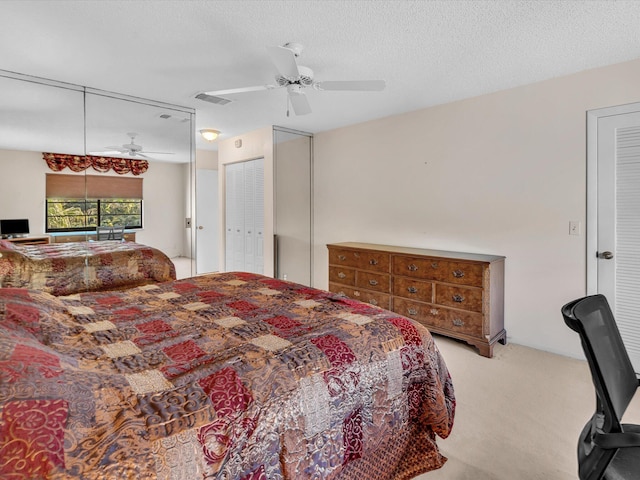 bedroom featuring visible vents, carpet floors, a textured ceiling, and ceiling fan