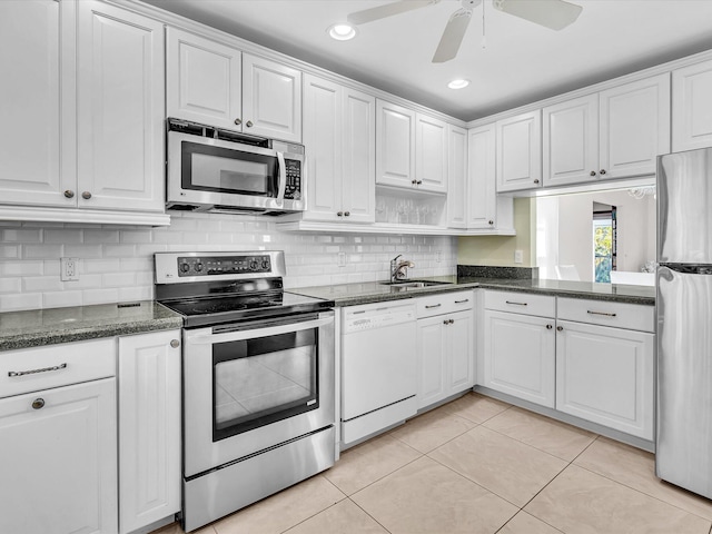 kitchen featuring light tile patterned floors, stainless steel appliances, white cabinetry, a ceiling fan, and a sink