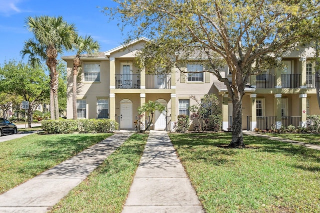 view of property featuring stucco siding and a front lawn