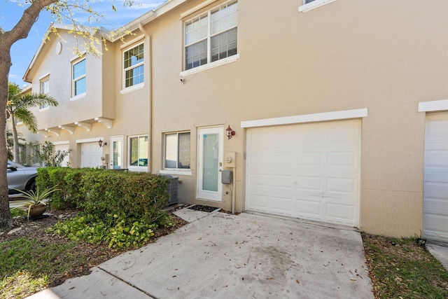 multi unit property with stucco siding and a garage