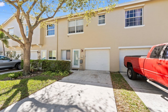 multi unit property featuring stucco siding, concrete driveway, and a garage