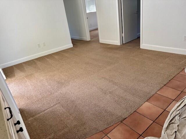 carpeted empty room featuring baseboards