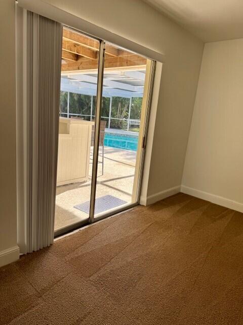 doorway to outside with carpet and baseboards