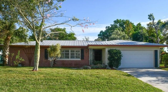 ranch-style house with a front lawn, driveway, an attached garage, metal roof, and brick siding