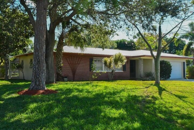 ranch-style house with a front yard, an attached garage, and brick siding