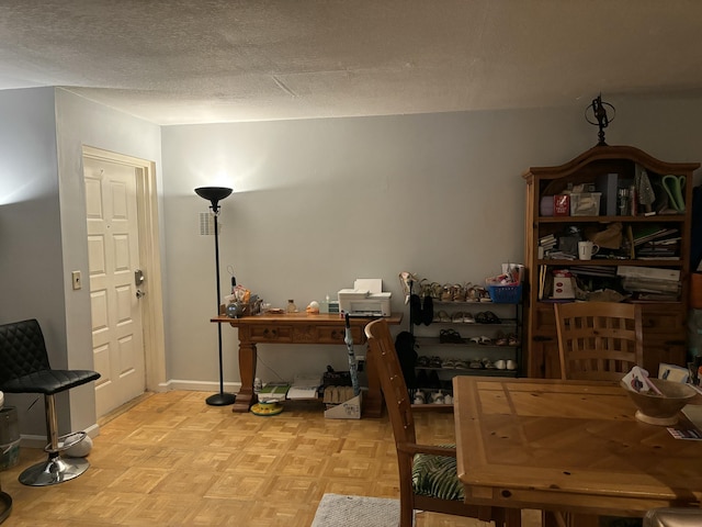 home office featuring a textured ceiling and baseboards