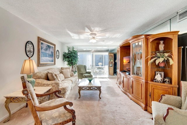 living area featuring a textured ceiling, light colored carpet, visible vents, and ceiling fan