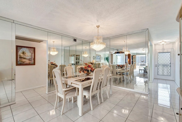 dining space featuring visible vents, a textured ceiling, a chandelier, and light tile patterned flooring