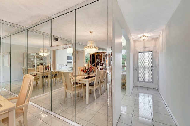 dining area with light tile patterned floors, visible vents, baseboards, and an inviting chandelier