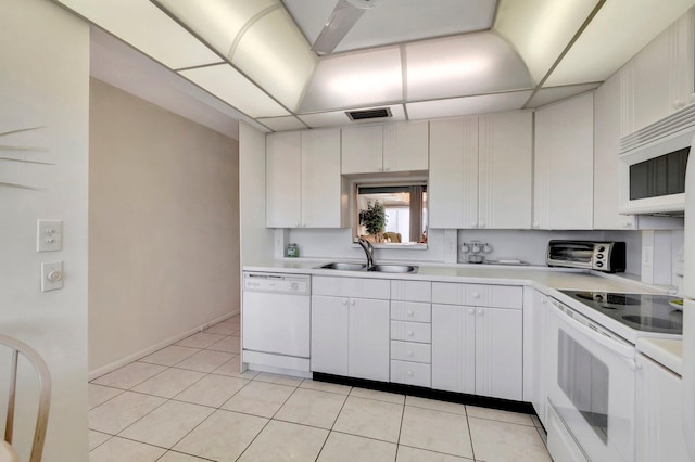 kitchen with visible vents, light countertops, light tile patterned floors, white appliances, and a sink