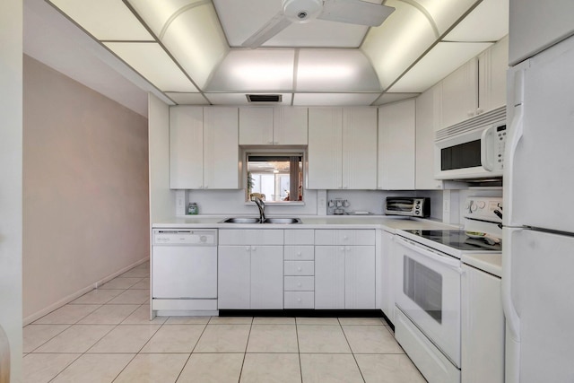 kitchen featuring white appliances, light tile patterned floors, visible vents, a sink, and light countertops