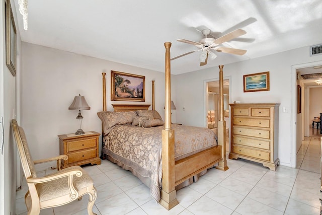 bedroom with light tile patterned floors, visible vents, connected bathroom, and a ceiling fan