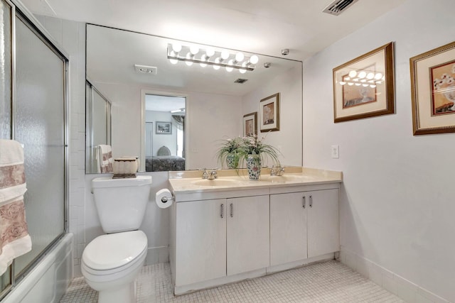 ensuite bathroom with visible vents, double vanity, a sink, tile patterned floors, and combined bath / shower with glass door