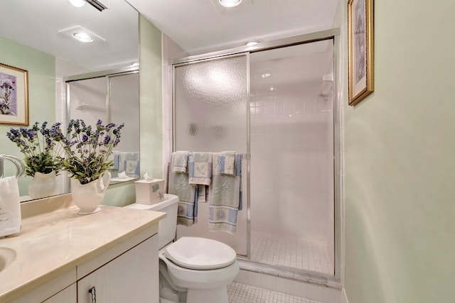 bathroom featuring toilet, a stall shower, vanity, and tile patterned flooring