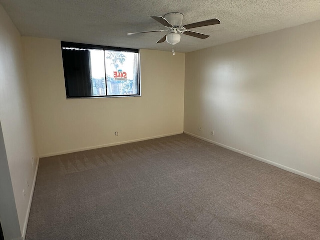 unfurnished room featuring ceiling fan, carpet, baseboards, and a textured ceiling