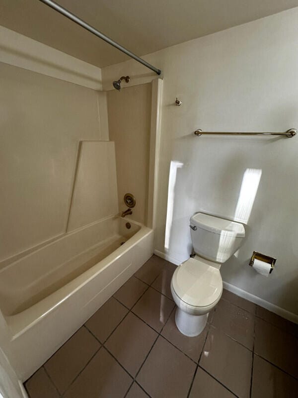 full bathroom with tile patterned flooring, baseboards, toilet, and bathtub / shower combination