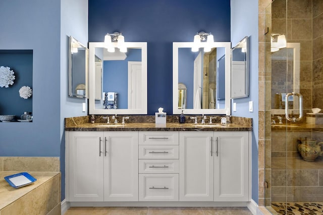 full bath featuring double vanity, a shower stall, and a sink