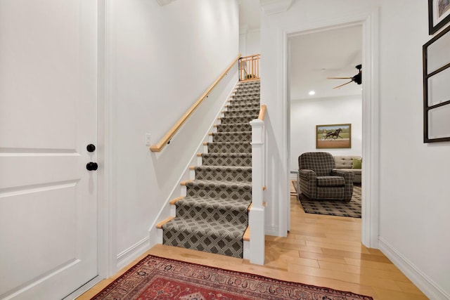 stairs featuring a ceiling fan, recessed lighting, wood finished floors, and baseboards