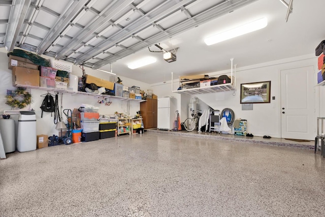 garage with a garage door opener and freestanding refrigerator