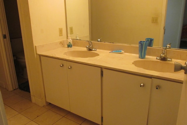 full bath featuring tile patterned flooring, double vanity, toilet, and a sink