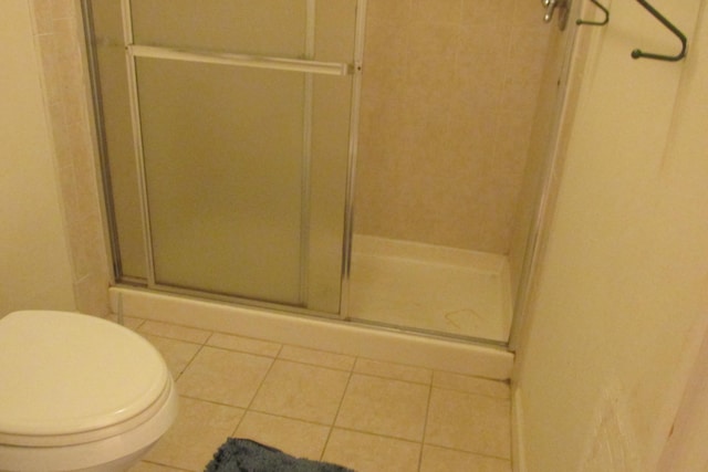 full bathroom with tile patterned floors, a shower stall, and toilet