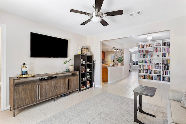 living room featuring ceiling fan, visible vents, baseboards, and light tile patterned flooring