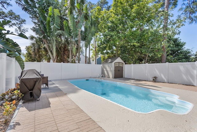 view of swimming pool featuring a fenced in pool, a shed, a fenced backyard, an outbuilding, and a patio