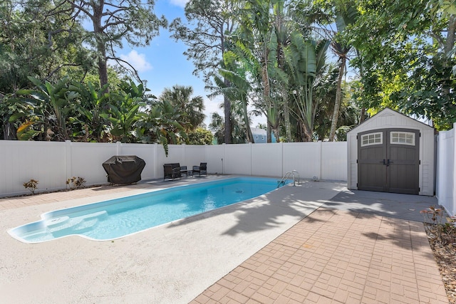 view of swimming pool featuring a patio, a fenced backyard, a shed, an outdoor structure, and a fenced in pool