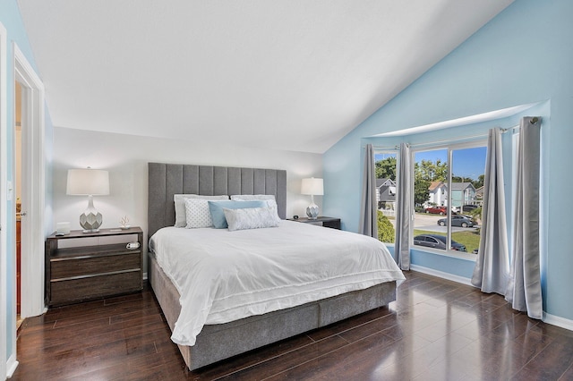 bedroom featuring dark wood finished floors, baseboards, and vaulted ceiling